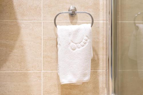 a white towel hanging on a shower door at MILDOM Express in Almaty