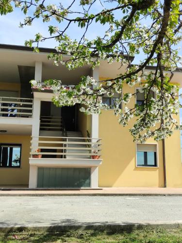 a yellow building with stairs and a balcony at Bastia Home Appartamento in Bastia Umbra