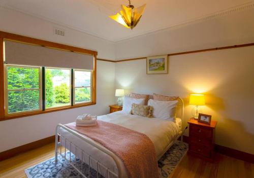 1 dormitorio con 1 cama grande y 2 ventanas en Elm Trees of Ross Cottage, en Ross
