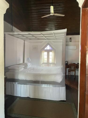 a bedroom with a white bed with a window at Old Courtyard Hotel in Cochin