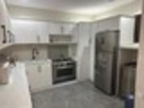 a kitchen with a stove and a refrigerator at شقة غرفتين وصاله وغرفة خادمة او سائق in Riyadh