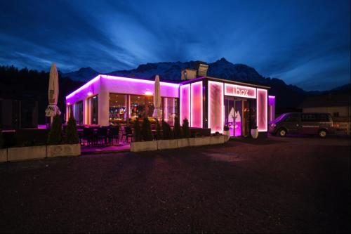 a building with purple lighting in a parking lot at Ibex Hostel in Nauders