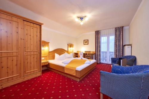 a hotel room with a bed and a room at Alpenhotel Rieger in Mittenwald