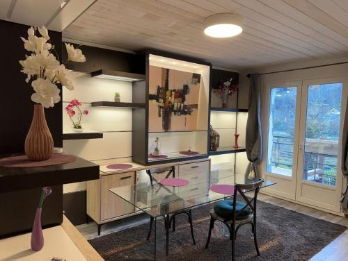 une salle à manger avec une table en verre et deux chaises dans l'établissement Les bains de l 'abbaye, à Lau-Balagnas