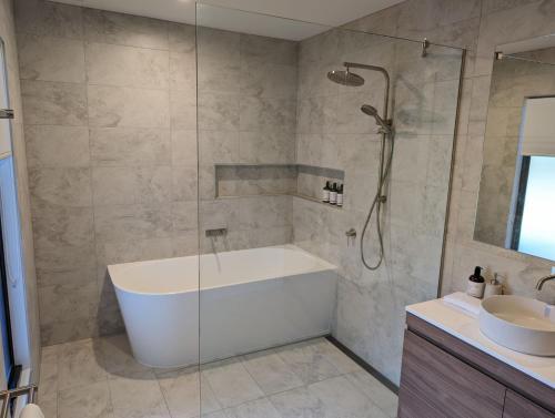 a bathroom with a bath tub and a sink at 52 Mountain Mist in Bright