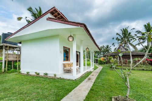 a small white house with a grass yard at Ritual Ubud in Gianyar