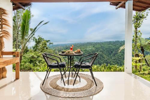 a table and two chairs on a patio with a view at Ritual Ubud in Gianyar
