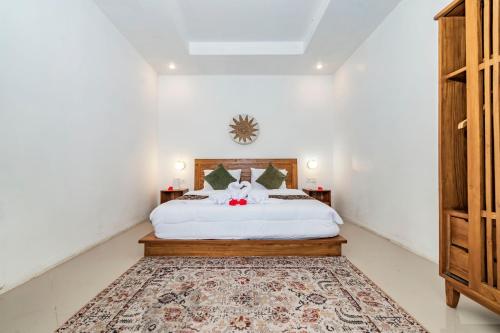 a bedroom with a white bed and a rug at Ritual Ubud in Gianyar