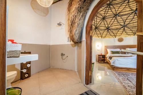 a bedroom with a bed and a toilet in a room at Ritual Ubud in Gianyar