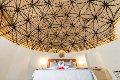 a bedroom with a bed with a large ceiling at Ritual Ubud in Gianyar