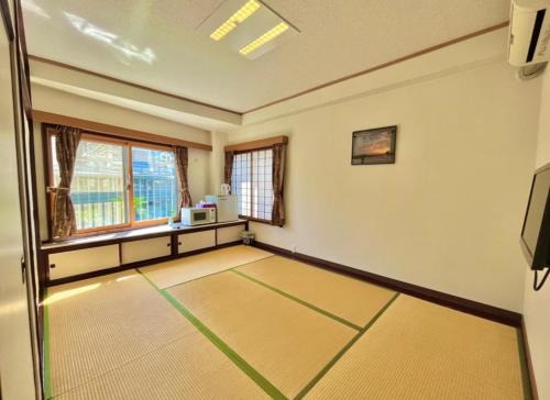 an empty room with a table and a window at Hostel and Cafe izu-no-umi in Atami