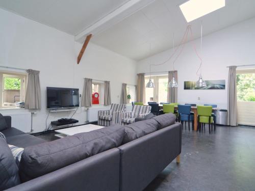 een woonkamer met een bank en een tafel en stoelen bij Cozy Holiday Home in Olst Wijhe with swimming pool in Olst