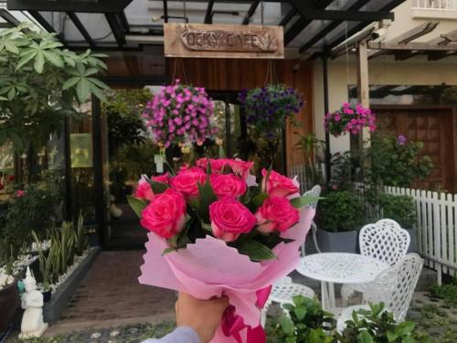 a person holding a bouquet of pink roses at Rocky Cafe & Mini Apartment in Siem Reap