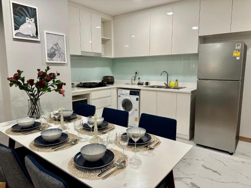 a kitchen with a table with chairs and a refrigerator at Astra Sky River Paronama Pool Luxury Changklan Chiang Mai in Chiang Mai