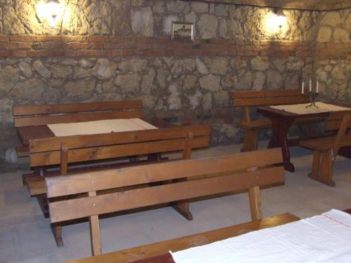 a room with benches and tables and a stone wall at Penzión Korzo in Štúrovo