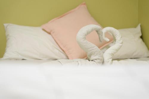 a pair of towel animals forming a heart on a bed at Silverfern Backpackers in Auckland