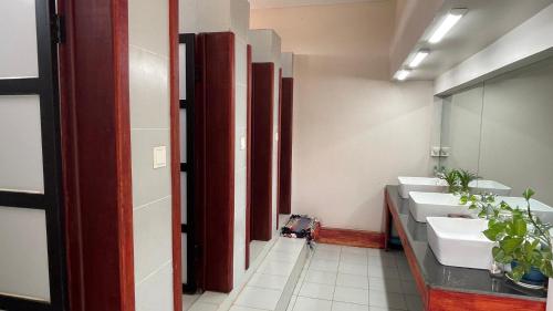a bathroom with three sinks and a row of mirrors at Rocky Cafe & Mini Apartment in Siem Reap