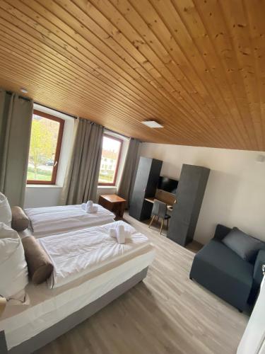 a bedroom with a large bed and a wooden ceiling at Fewo Nahe - Hostel für Erwachsene in Bad Sobernheim
