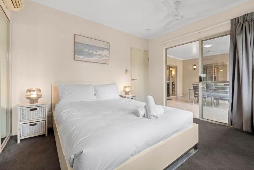 1 dormitorio blanco con 1 cama grande y comedor en Discover a Lush Poolside Stay at The Lakes Resort, en Cairns North