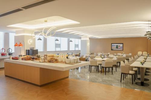 a restaurant with tables and chairs in a room at Atour Hotel Xiamen North Station Jiageng Stadium in Xiamen