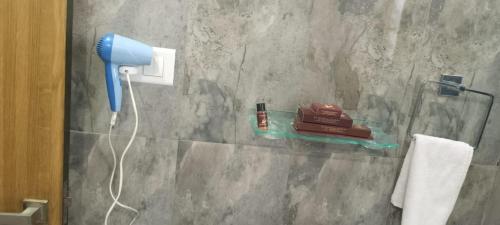 a bathroom with a blow dryer on a stone wall at Hotel Jk Residency in Muzaffarpur