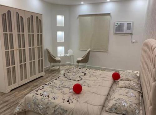 a bedroom with a bed with red balls on it at استراحة وشاليهات عزيزه in Al Wajh