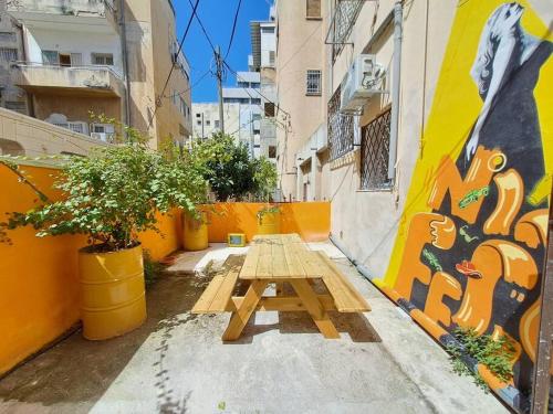 una mesa de picnic en un callejón junto a un edificio en Fellini Nine ground (talpiot), en Haifa