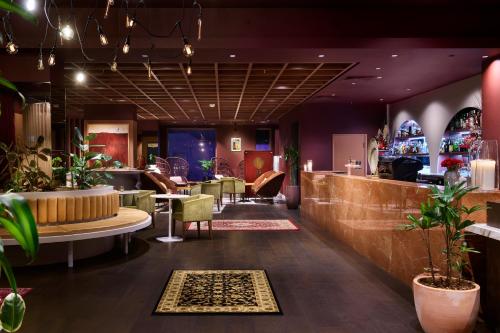 a lobby with a bar with plants and chairs at Pan Pacific Perth in Perth