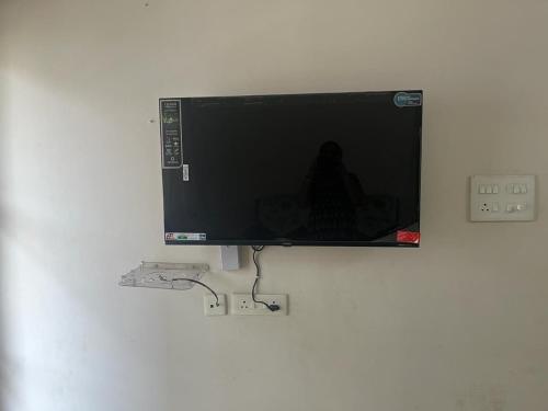 telewizor z płaskim ekranem wiszący na ścianie w obiekcie 2 BHK Apartment at Gachibowli w mieście Hajdarabad