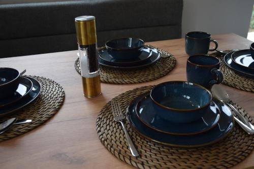 a wooden table with black cups and plates on it at Lenau Apartment in Gmunden