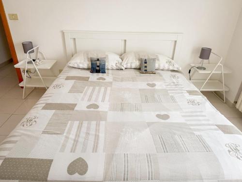 a bedroom with a large bed with a quilt on it at La casa di Lory in Falconara Marittima