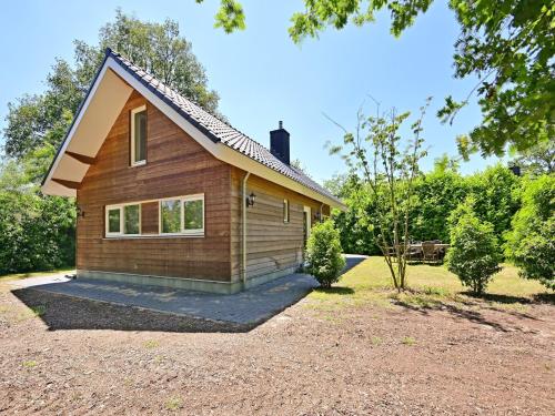 uma pequena casa com um telhado inclinado em Chalet with gorgeous view of the natural surroundings em Weerselo