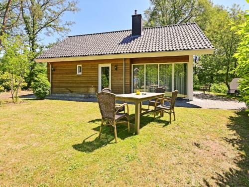 einen Tisch und Stühle vor einem Haus in der Unterkunft Chalet with gorgeous view of the natural surroundings in Weerselo