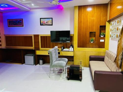 uma sala de estar com um sofá e cadeiras e uma televisão em Hotel Jk Residency em Muzaffarpur