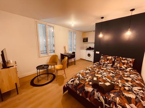 a bedroom with a bed and a desk and a kitchen at Le Deep Blue - Centre historique - Wifi et TV connectée - Stationnement aisé in Niort