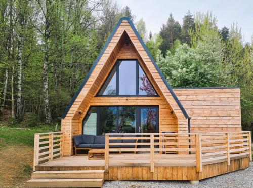 a cabin with a large window on a wooden deck at Mountains & Lakes - Chaletdorf & Appartements in Villach