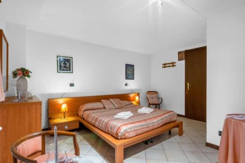 a bedroom with a bed and a table and a chair at Cherry House with Pool, Solarium Area and Barbecue in Manerba del Garda