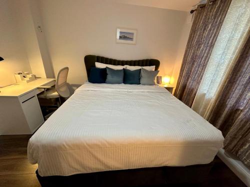 een slaapkamer met een groot wit bed met blauwe kussens bij Big Cozy Room near City Center in Dublin