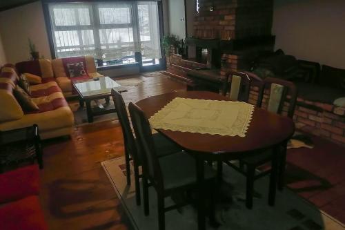 uma sala de jantar com uma mesa e cadeiras e um sofá em Vikendica Verići- Banja Luka em Jankovići