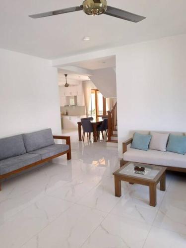 a living room with two couches and a table at Comfortable & serene stay at Red Rocks villa in Rajagiriya