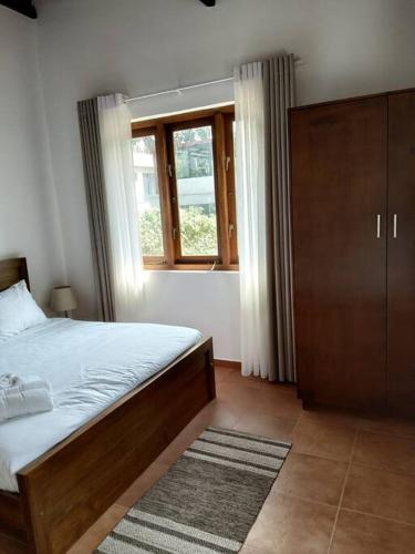 a bedroom with a bed and a window at Comfortable & serene stay at Red Rocks villa in Rajagiriya