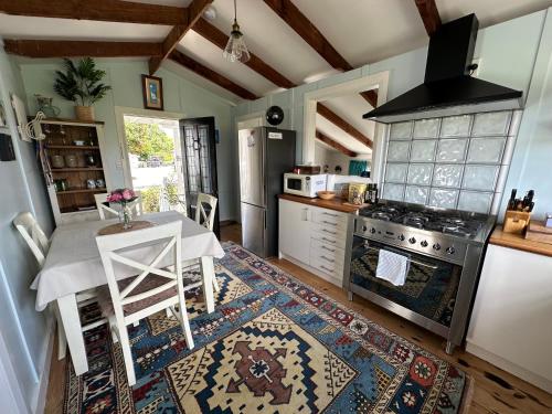 a kitchen with a table and a stove at The Cottage at The Willows in Cambridge
