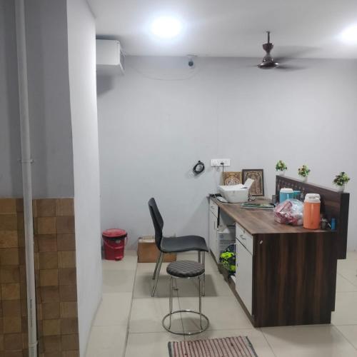 a kitchen with a counter and a chair in a room at AB Residency in Coimbatore