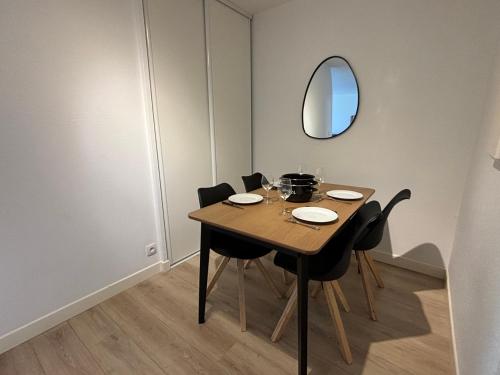 - une table à manger avec des chaises et un miroir dans l'établissement T2 Arcachon vacances et plages a 300 mètres, à Arcachon