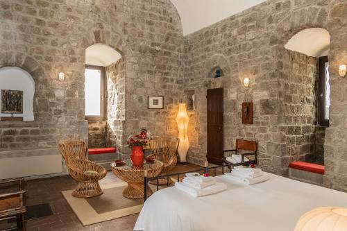 een kamer met stenen muren en een tafel en stoelen bij Torre dei Belforti in Montecatini Val di Cecina