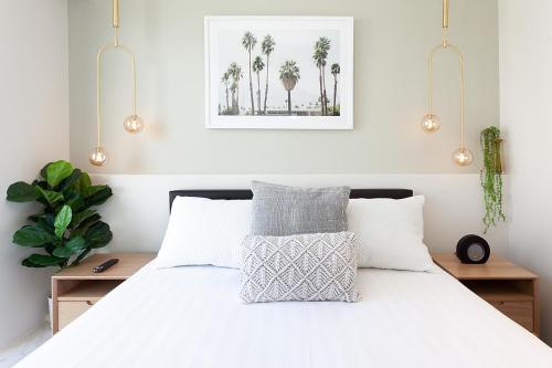 een slaapkamer met een wit bed met palmbomen bij Perfect Located 2-Bed with Spacious Balcony & BBQ in Sydney