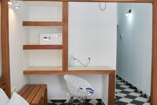 a room with a table and a microwave and a chair at JIRAJIRA HOTEL in Nosy Be