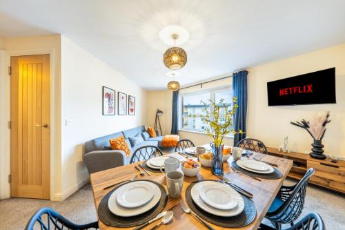a dining room and living room with a wooden table and chairs at 2 Bedroom Apartment in Hatfield - Gated Free Parking - Amazing for Contractors - Private Bathrooms - Near University & Business Park - Big savings on Longer Stays in Hatfield