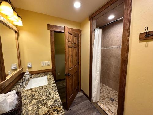a bathroom with a walk in shower and a sink at Yellowstone Cabins and RV in West Yellowstone