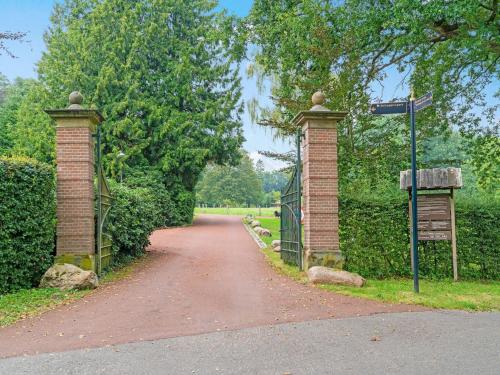 a gate on a dirt road with a driveway at Picturesque Holiday Home in Oldenzaal with Jacuzzi in Oldenzaal